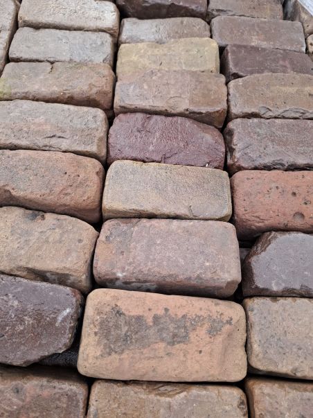 Zeer oude klinkerkeien op pallets rood genuanceerd.